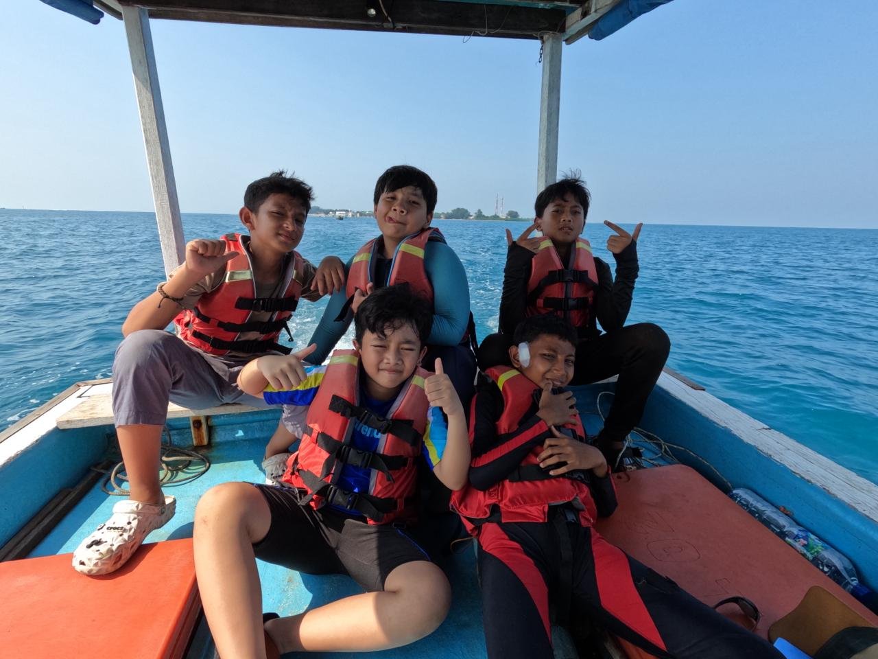Young participants wearing life jackets on a boat
